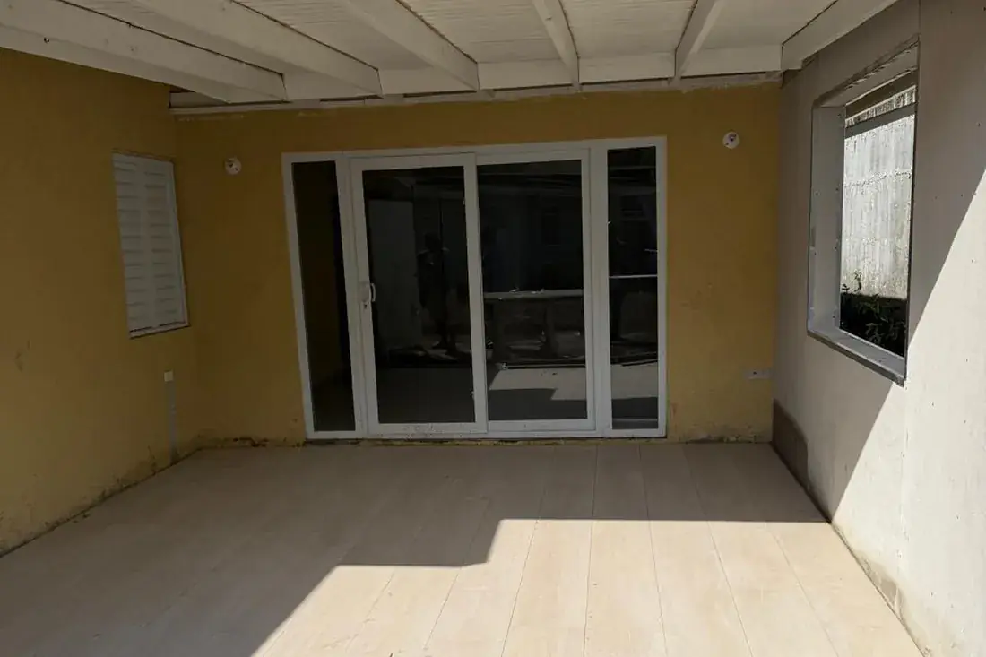 The same addition finished, rendered and painted with a tiled floor and new sliding doors in
