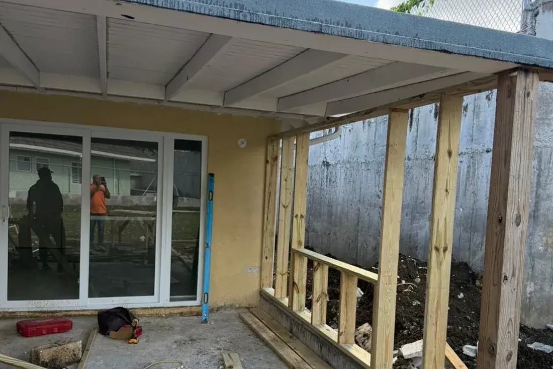 An addition mid build, timber studwork open to the yard under a new roof slab
