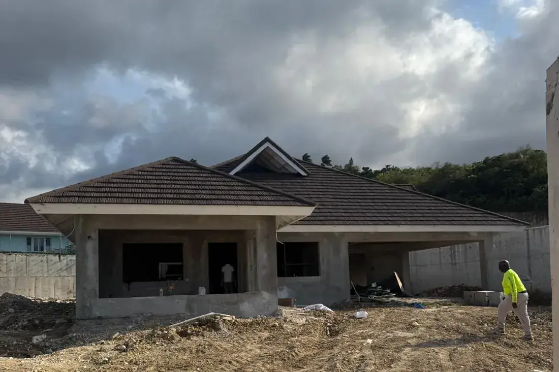 The same house at block and roof stage, bare concrete, no windows and the ground still raw