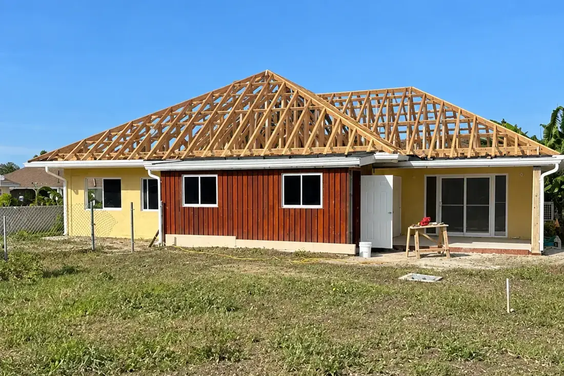 The house with the roof trusses set out and braced, open to the sky