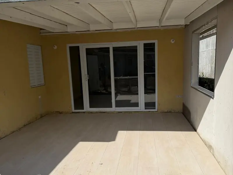 The same addition finished, rendered and painted with a tiled floor and new sliding doors in
