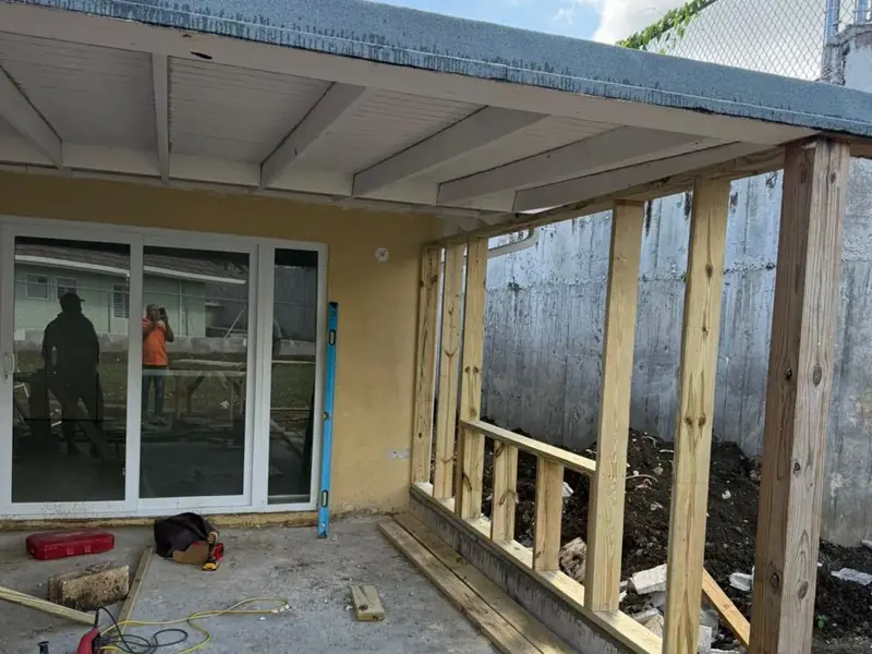 An addition mid build, timber studwork open to the yard under a new roof slab