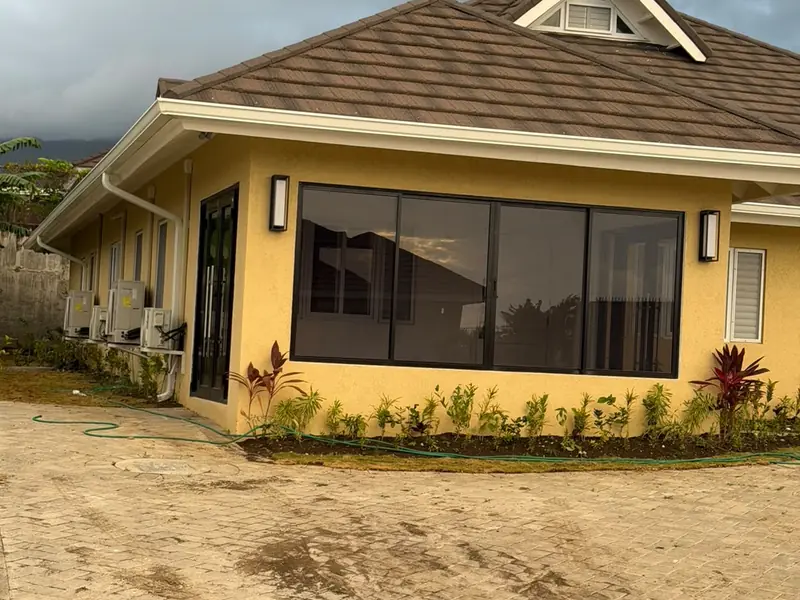 A completed single storey house with a bay window and planted borders