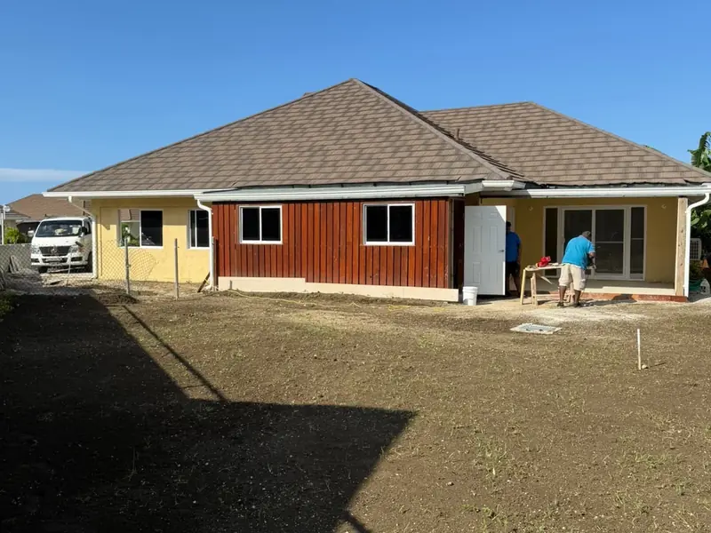 The front of a finished house with timber cladding and a cleared driveway