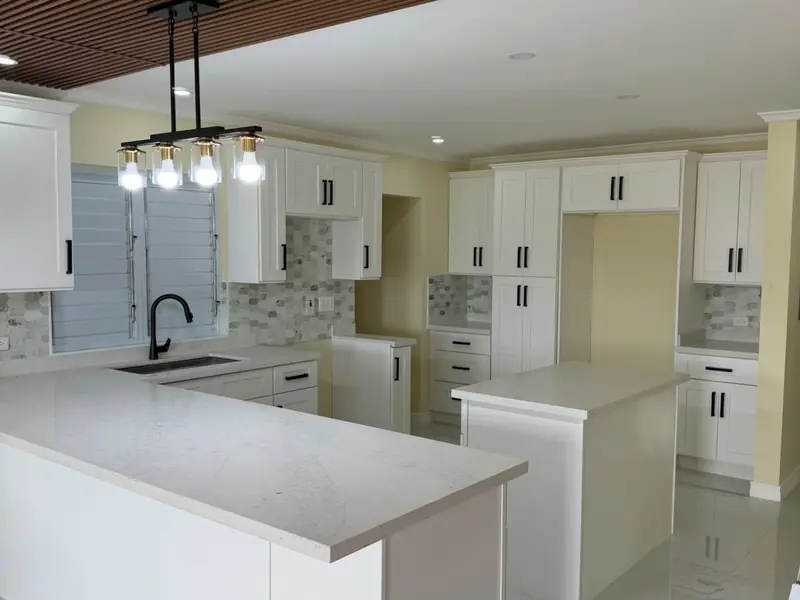 A finished kitchen and dining space with a timber slatted ceiling and pendant lights