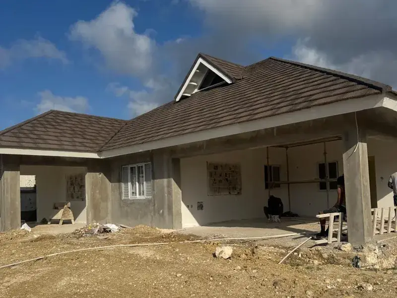 A new build at block and roof stage, the hipped roof on and the walls still bare concrete