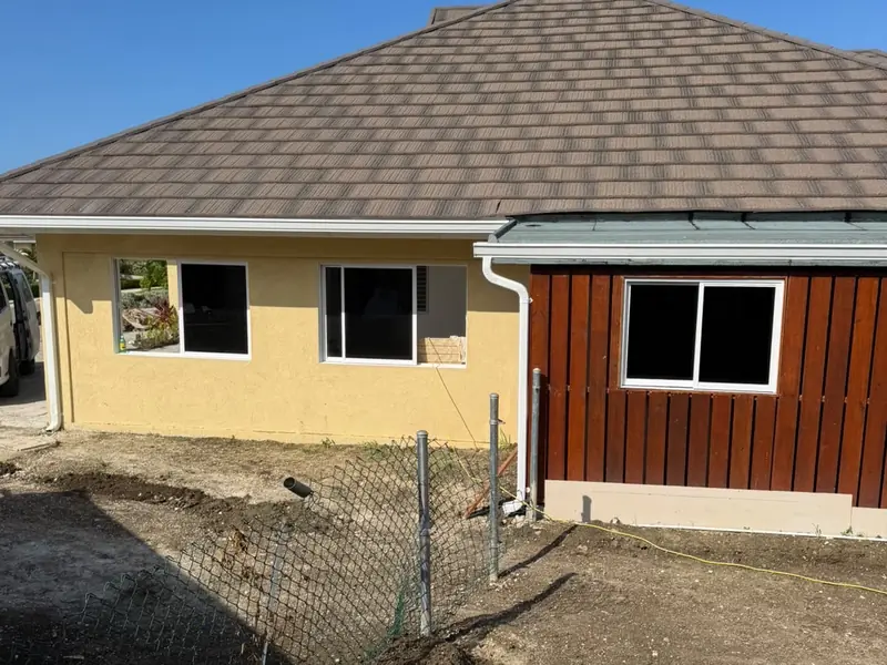 A finished house showing the hipped roof, render and timber cladding